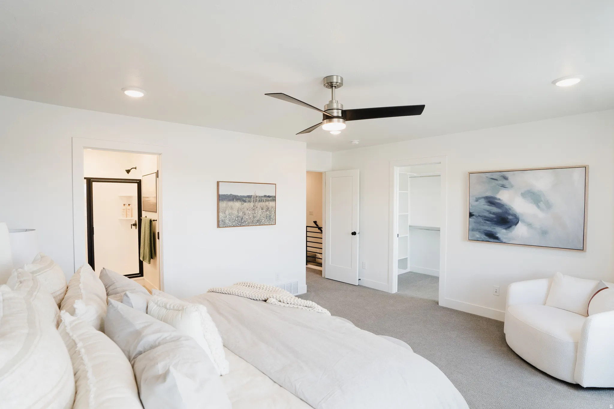 Bright bedroom featuring neutral-toned carpeting, a contemporary ceiling fan, and recessed lighting