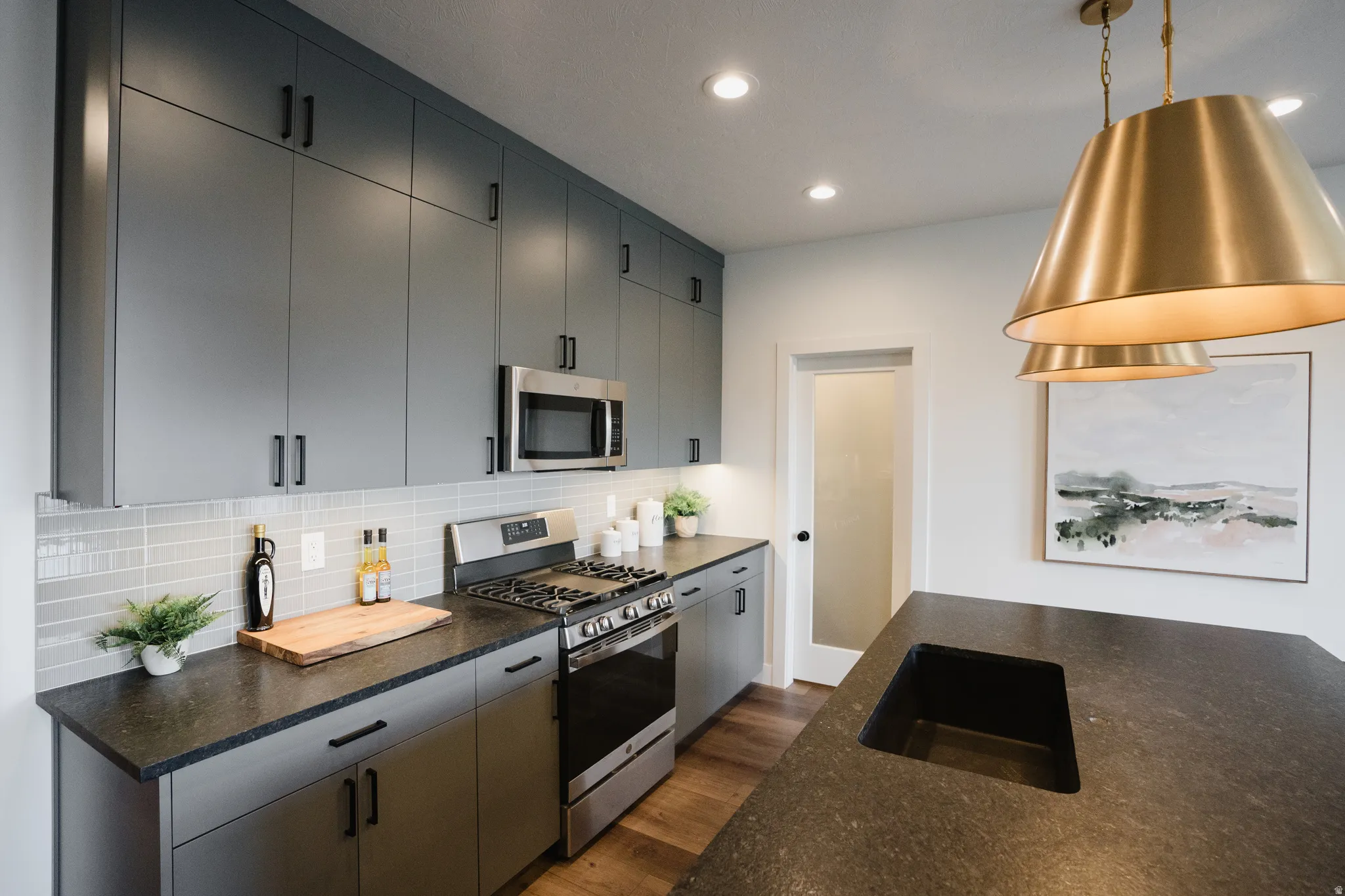 Modern kitchen featuring dark cabinetry with contrasting black hardware