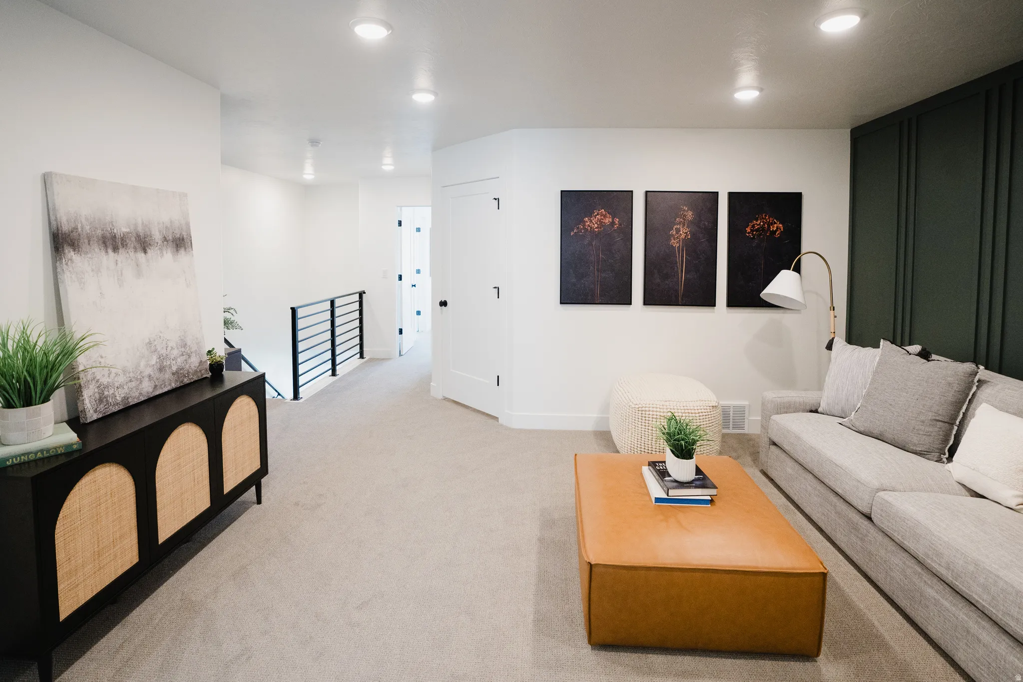 Carpeted living area featuring a dark green accent wall with vertical paneling