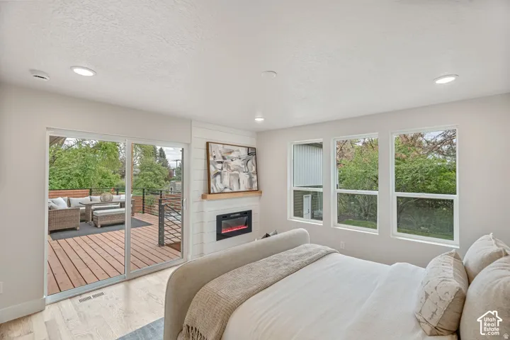 Wood-finish flooring throughout, with a built-in fireplace featuring a white tile surround and wood mantel