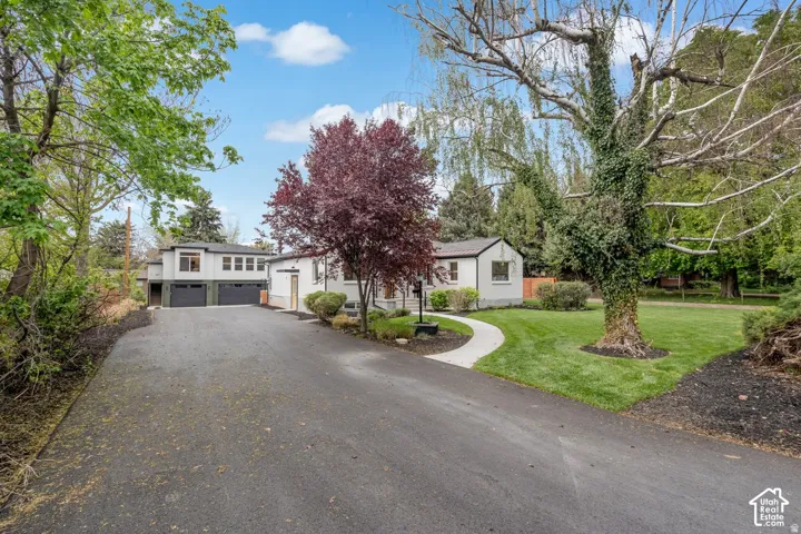 Expansive paved driveway leading to a multi-structure property