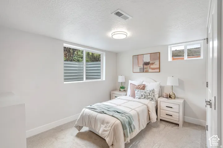 Bedroom featuring white walls, textured carpeting, and a flush-mount ceiling light fixture