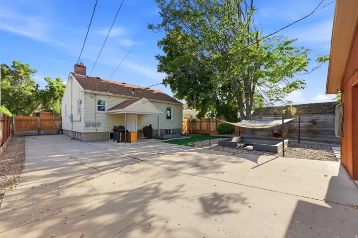 Expansive concrete patio area with a covered entryway and gravel landscaping