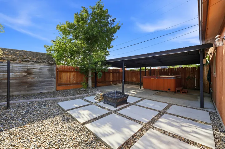 Backyard featuring a covered patio and concrete paver pathway