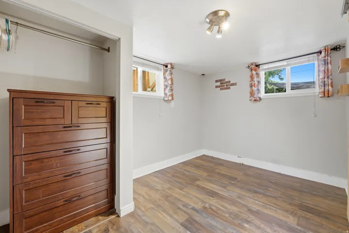 Room featuring wood-finish flooring, light grey walls, and a recessed window