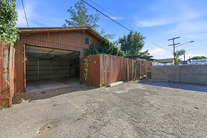 Back of garage with door exiting to the open area behind the house, industrial and residential easement.