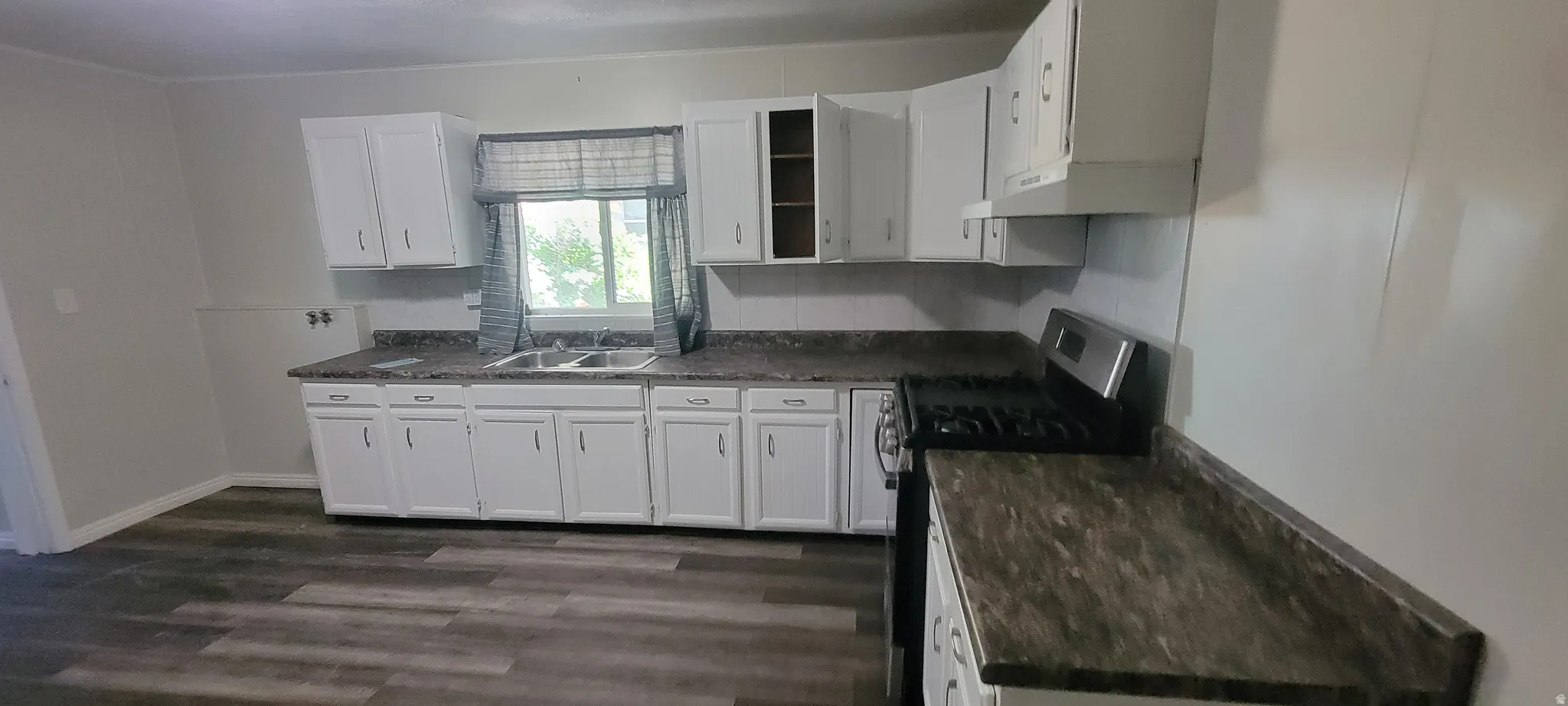Kitchen featuring white cabinetry with brushed nickel hardware and a triple basin sink