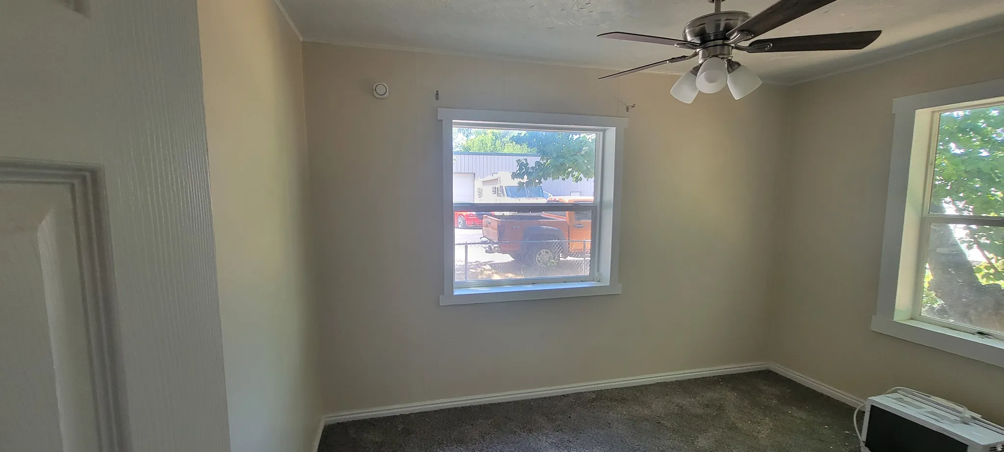 Room featuring light neutral wall paint and textured carpeting