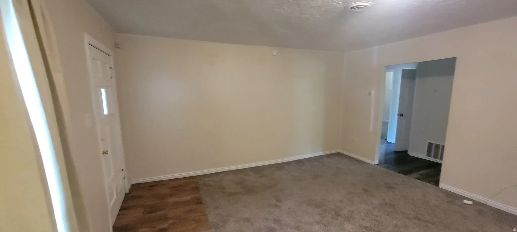 Living area with neutral wall tones and varied flooring