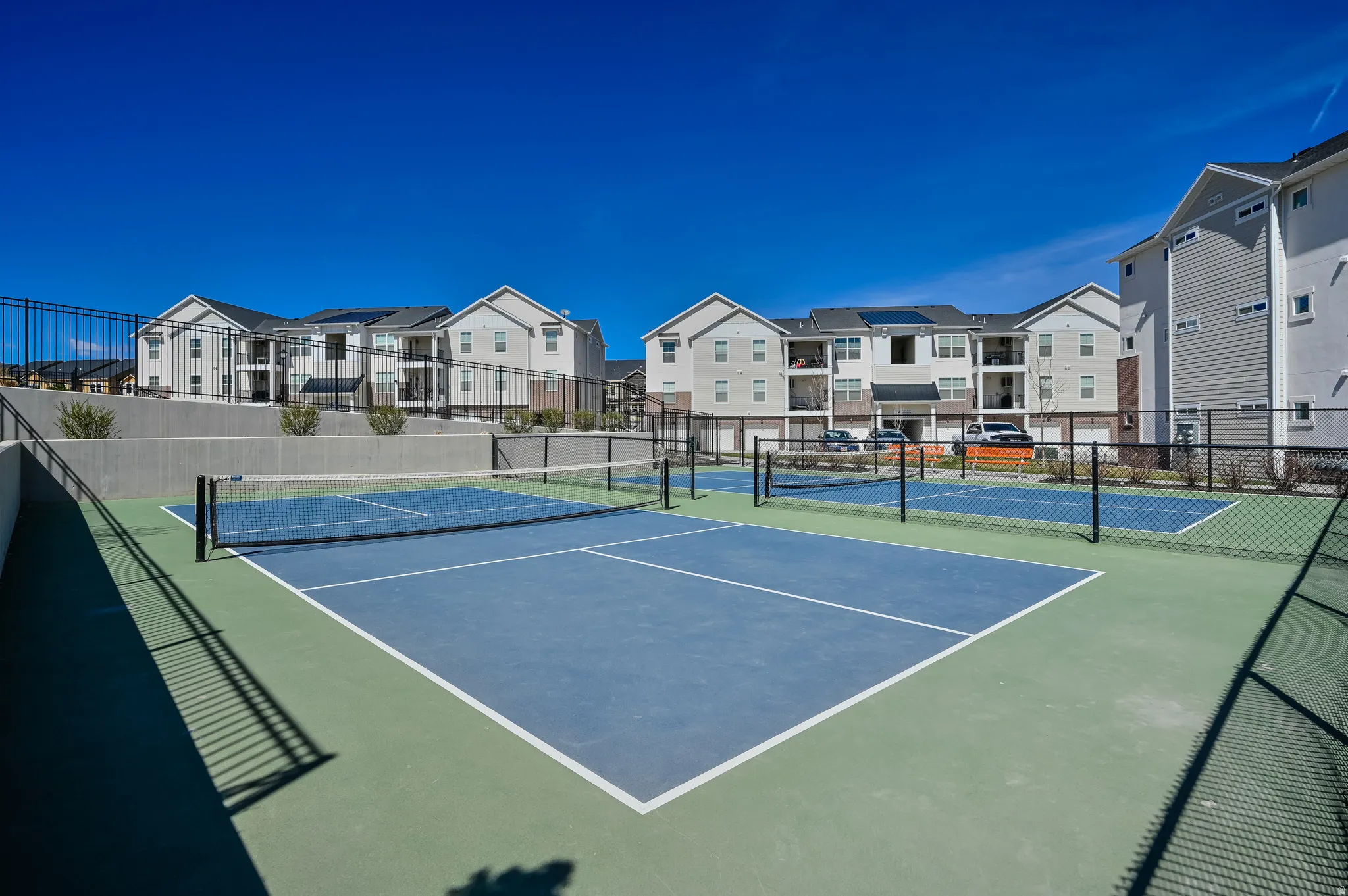 Sport court facility featuring two blue and green courts with black netting
