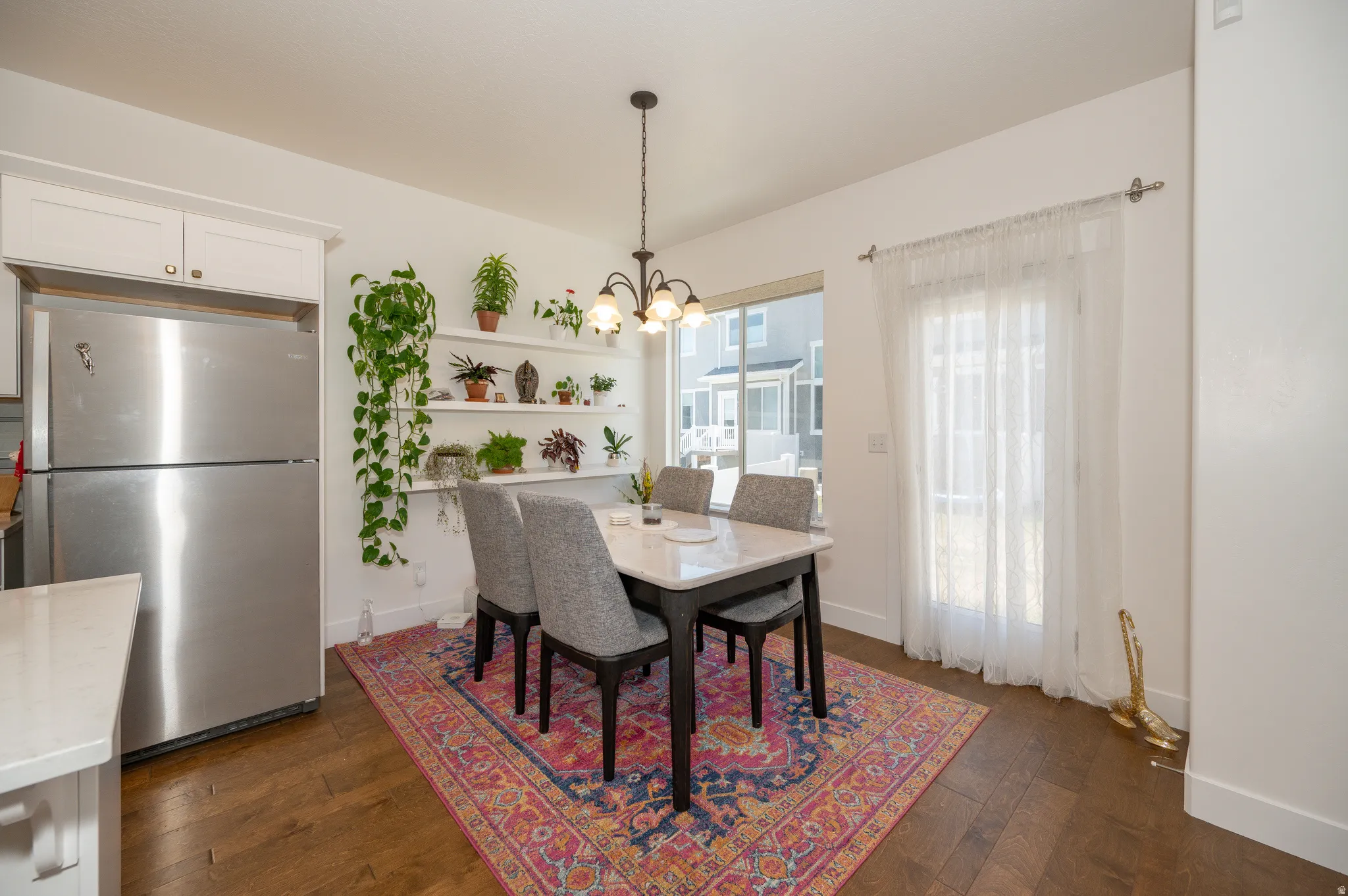 Dining area featuring wood-finish flooring, a pendant light fixture, and a glass-paneled door