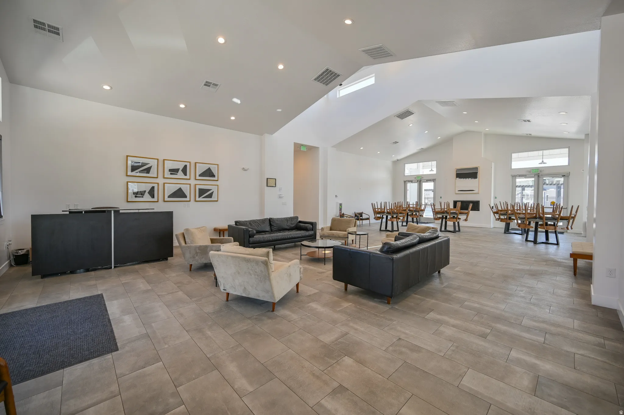 Spacious common area featuring vaulted ceilings, recessed lighting, and wood-finish flooring