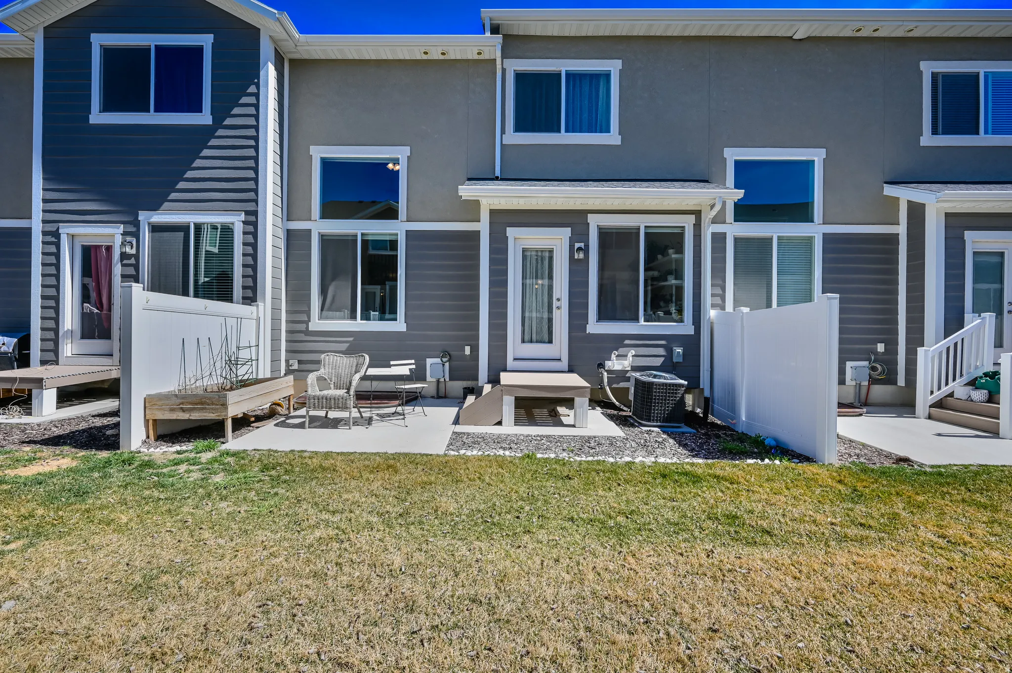 Private patio area featuring concrete paving, a built-in privacy fence, and direct exterior access