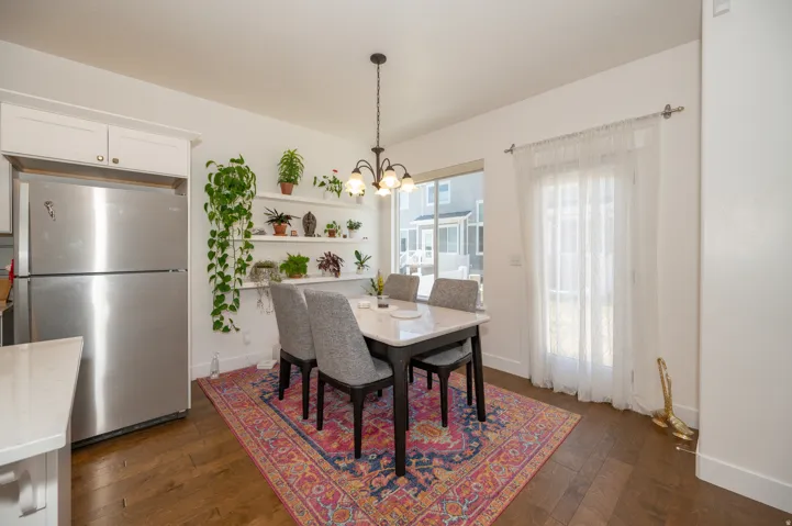 Dining area featuring wood-finish flooring, a pendant light fixture, and a glass-paneled door