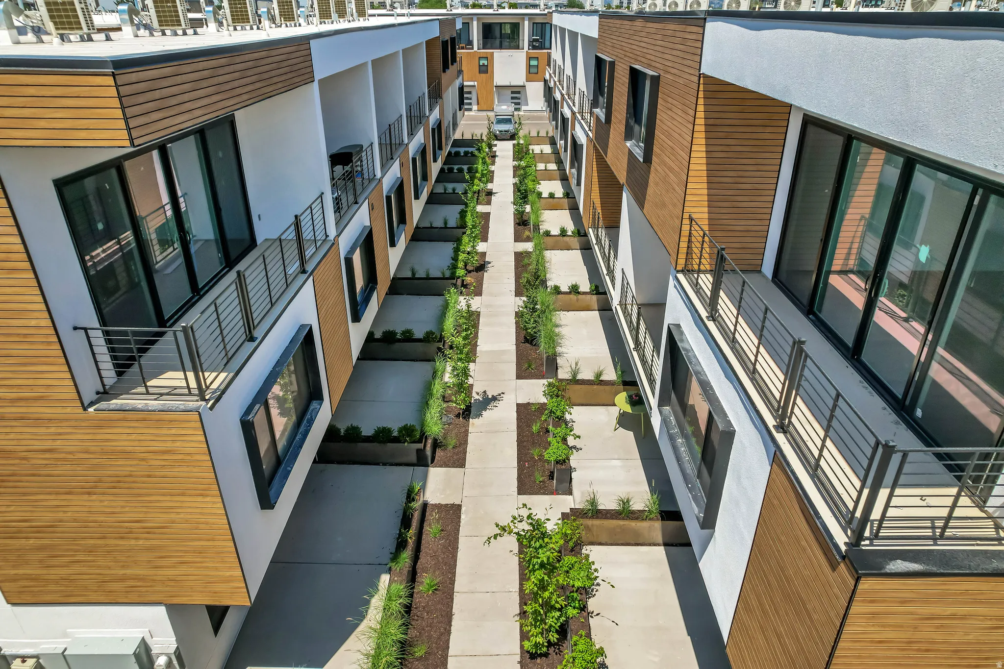 Contemporary multi-story facades featuring wood-look paneling and white stucco