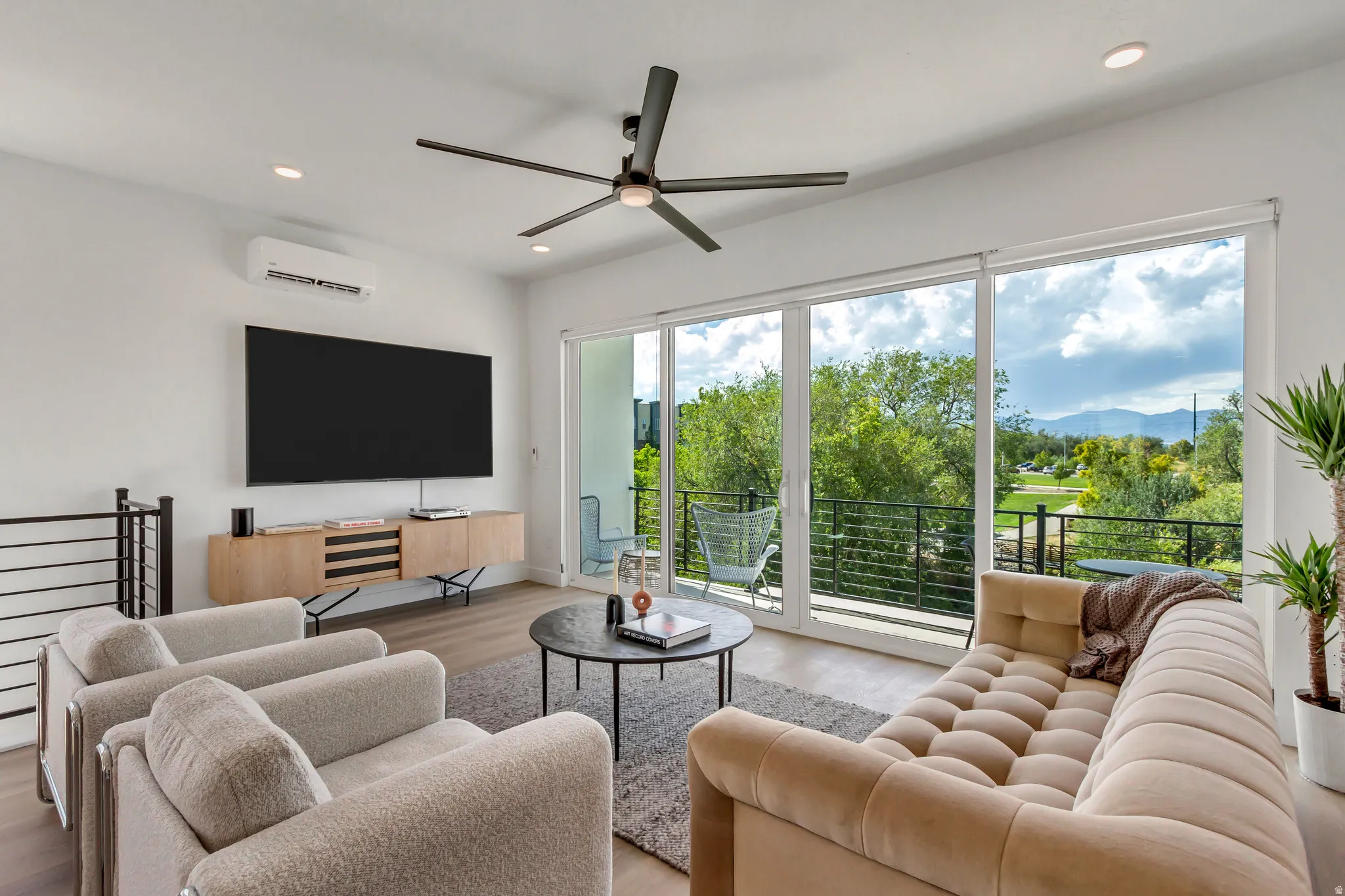 Living area featuring wood-finish flooring, recessed lighting, and a modern ceiling fan
