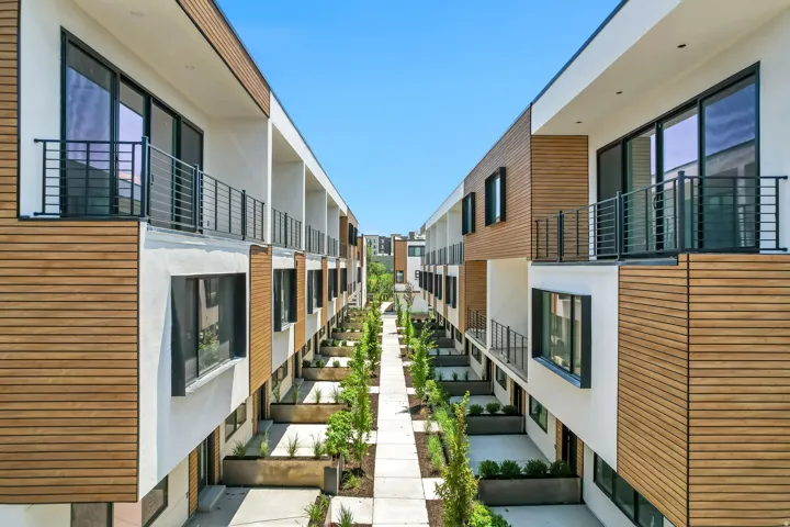 Modern architectural facade featuring white stucco and wood-finish paneling