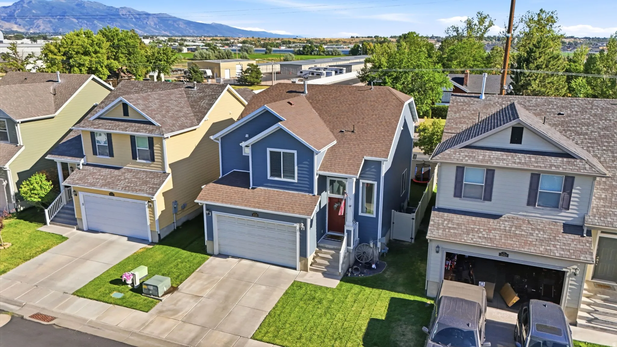 Two-story residence featuring blue siding, a brown shingle roof, and an attached two-car garage