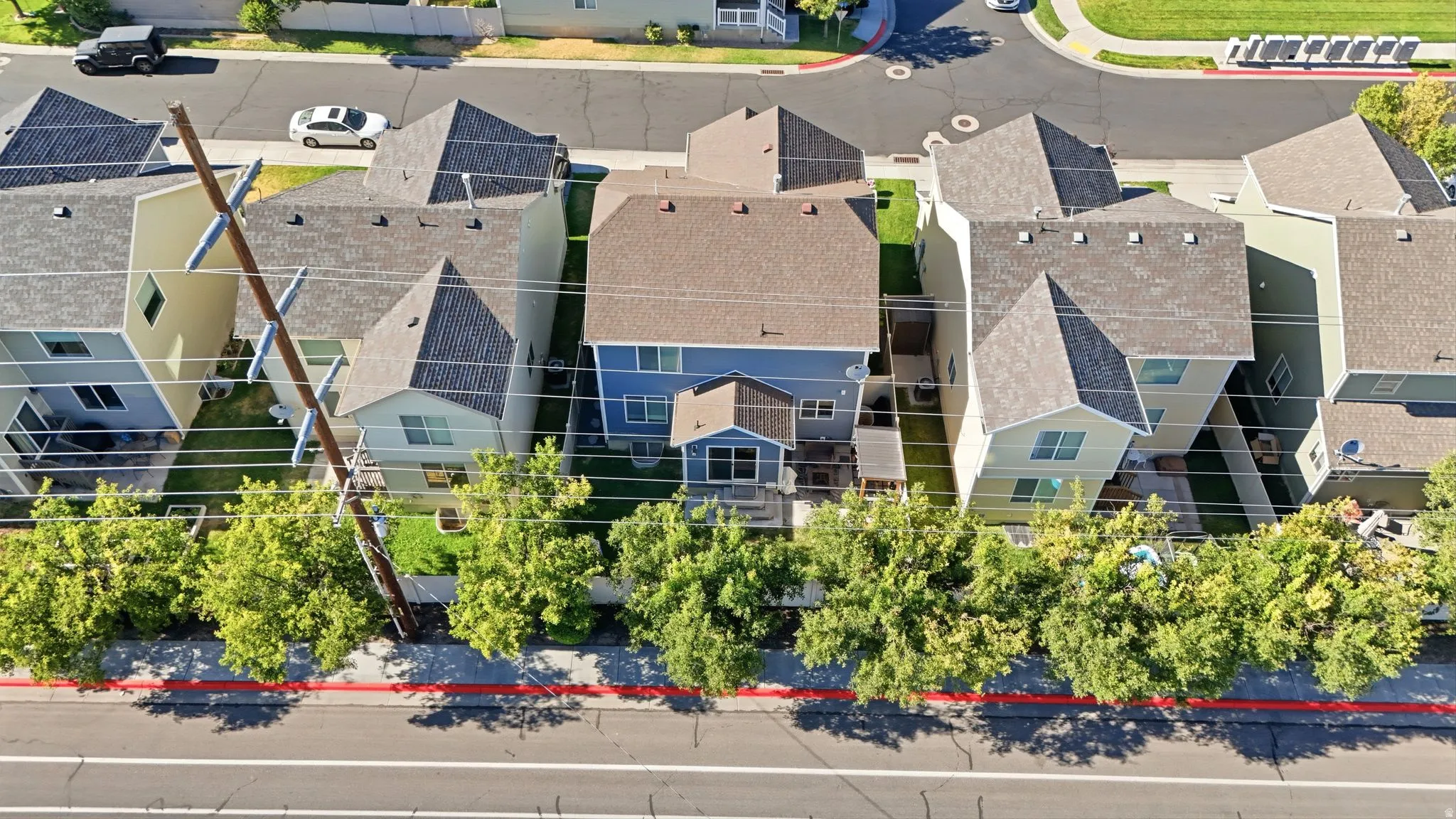 Aerial perspective of a residential street with multiple properties featuring asphalt shingle roofs and two-story elevations