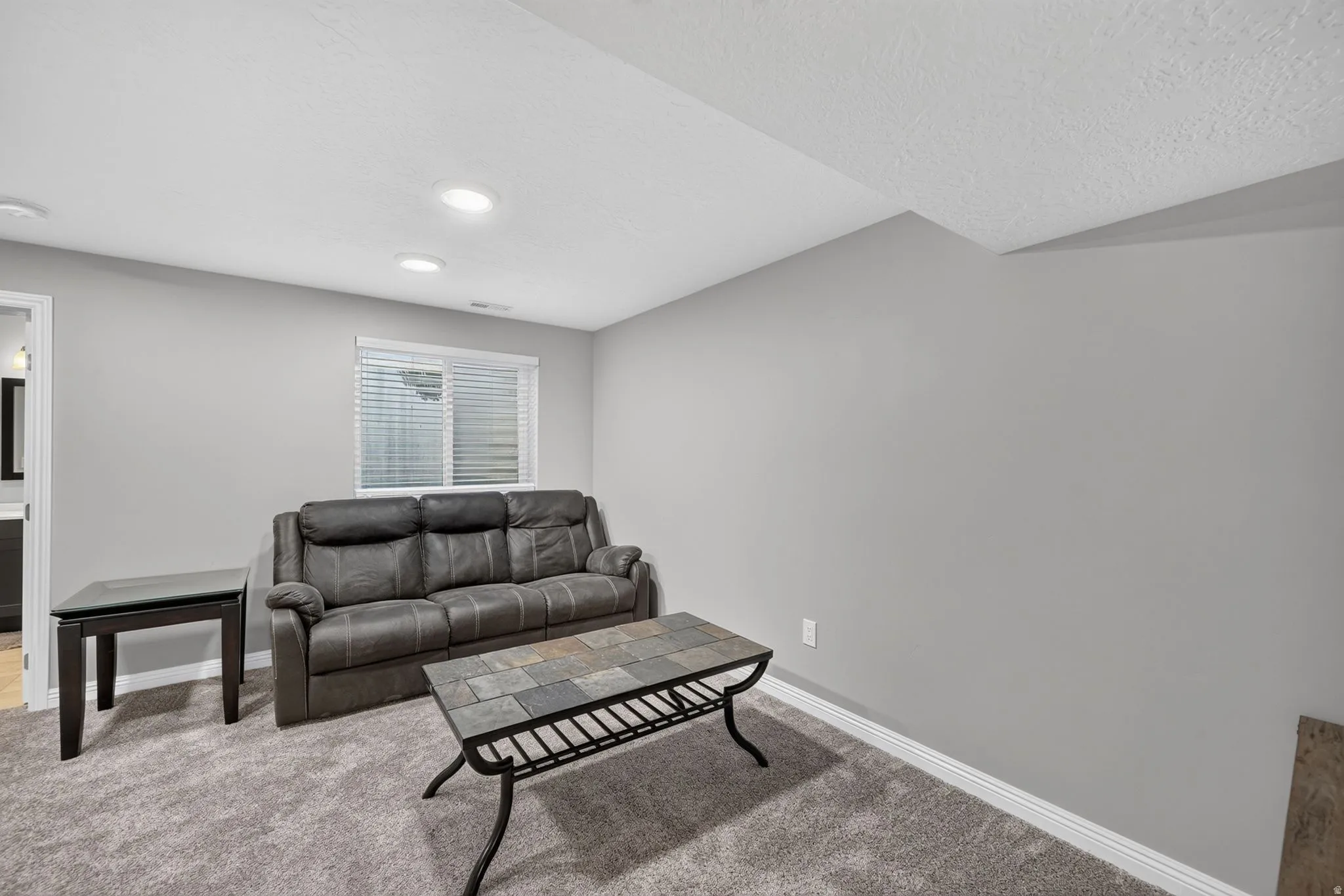 Carpeted room featuring light gray walls and recessed lighting