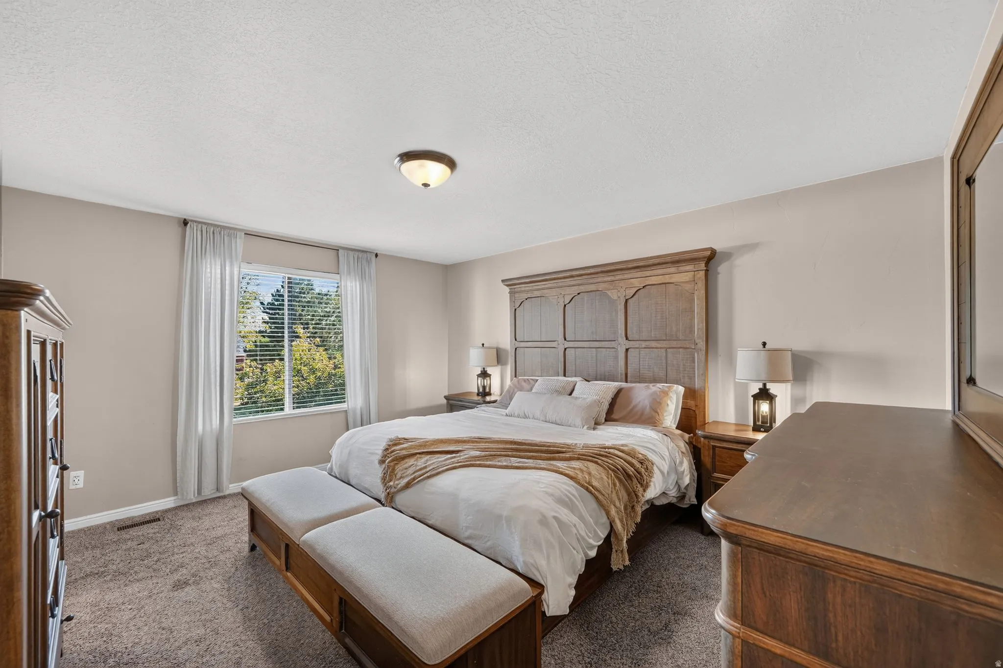 Carpeted bedroom featuring neutral wall tones and a window with white blinds