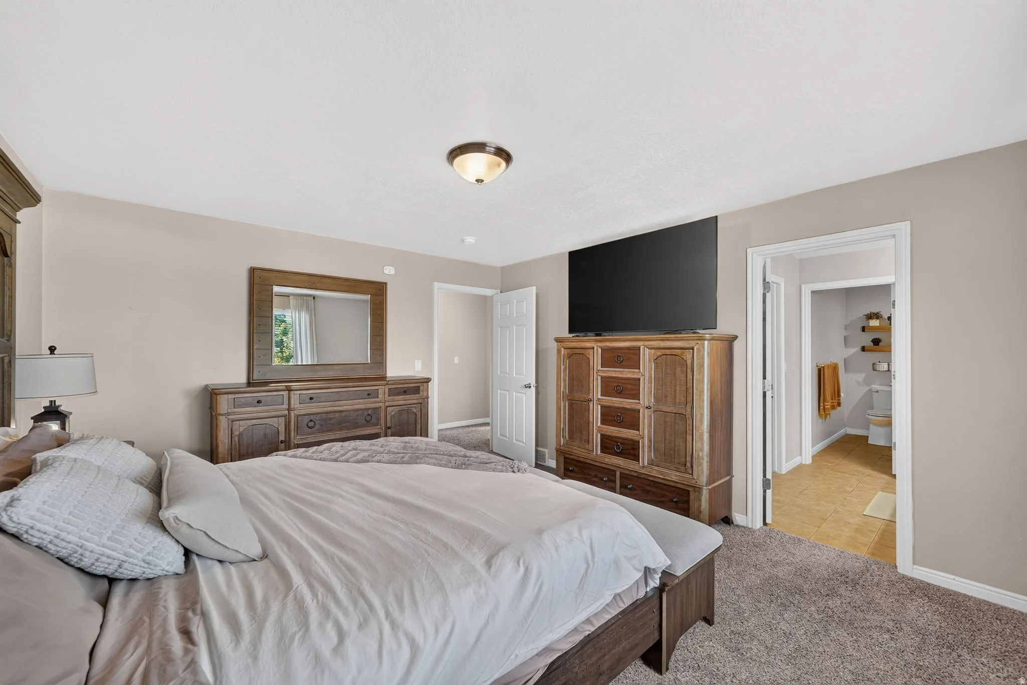 Spacious room with neutral wall tones and textured carpeting