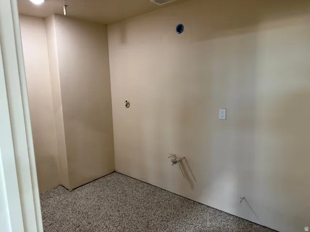 Utility space featuring neutral wall paint and a speckled epoxy floor finish