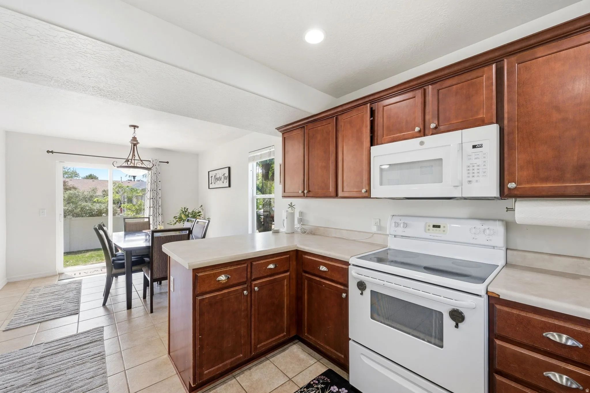 Kitchen featuring wood-finish cabinetry and light-toned countertops