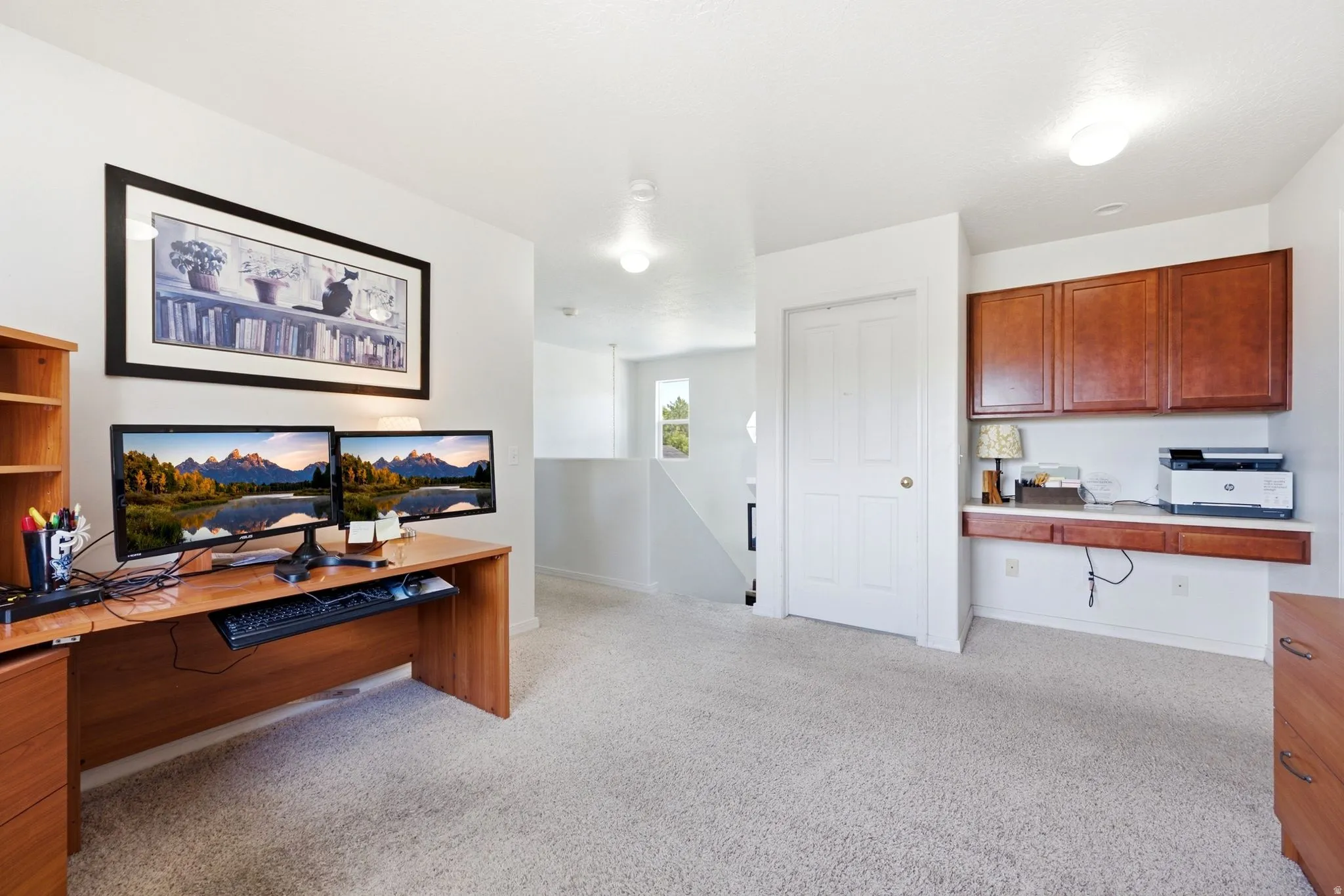 White walls and light carpet flooring create a neutral backdrop for a dedicated workspace