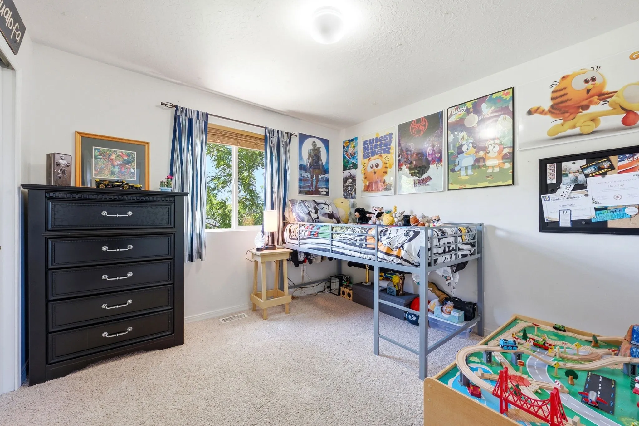 Carpeted room featuring a window with natural light, a ceiling-mounted light fixture, and white walls