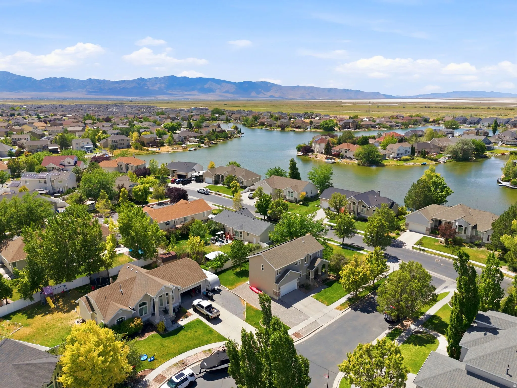 Residential community featuring diverse single-family homes, mature trees, and a prominent lake