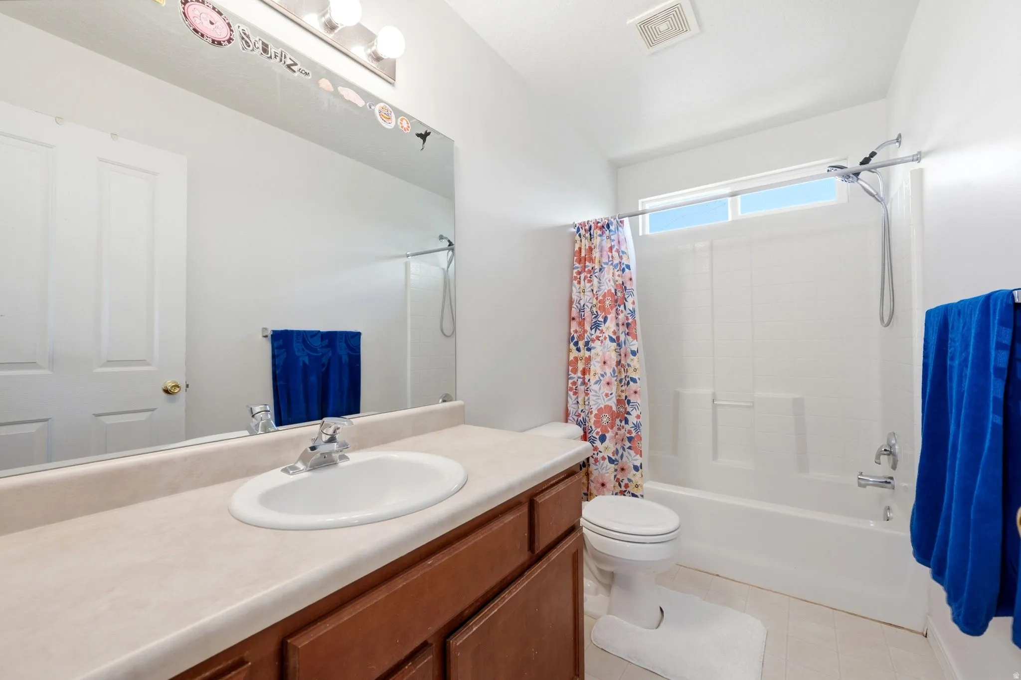 Bathroom with a single vanity featuring a laminate countertop and wood cabinetry