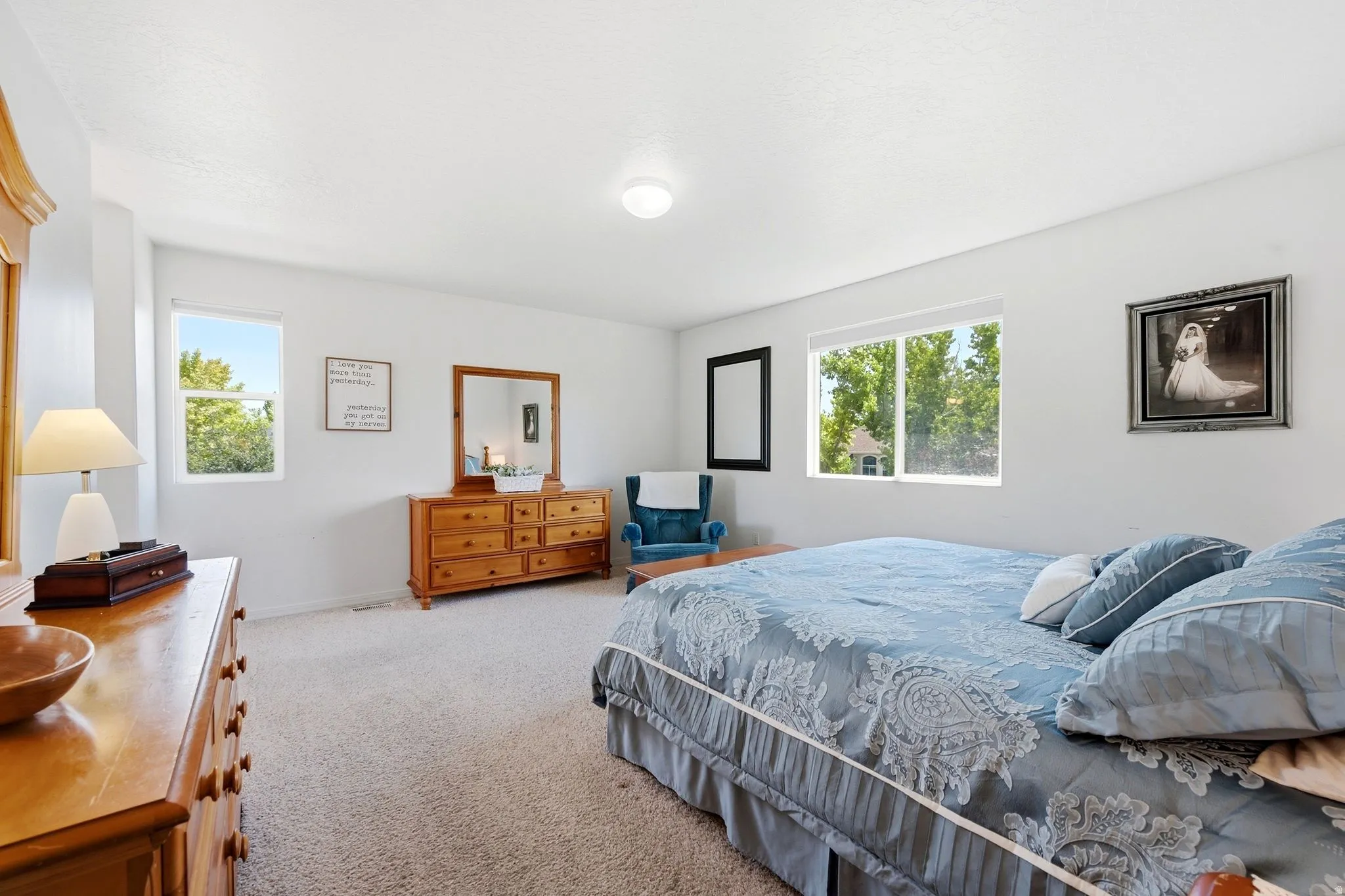 Carpeted bedroom featuring white walls and multiple windows