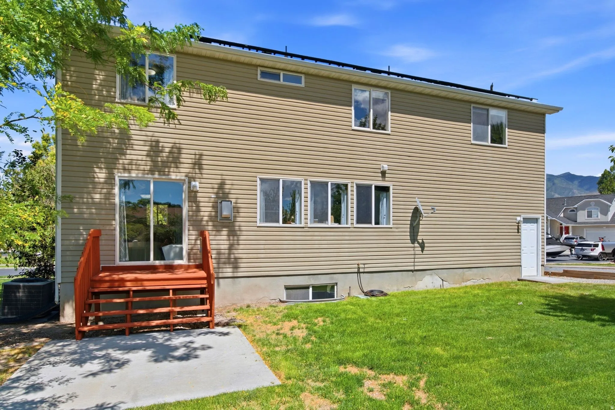 Two-story exterior with horizontal siding and a green lawn