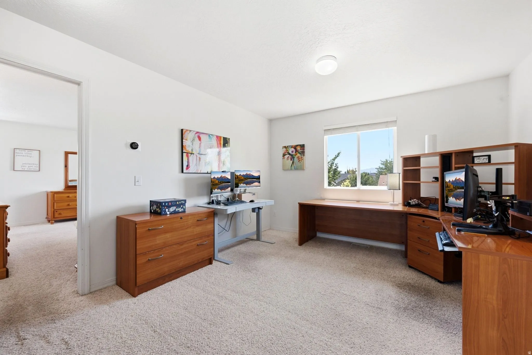 Spacious room featuring carpeting, light-toned walls, and a large window offering outdoor scenery