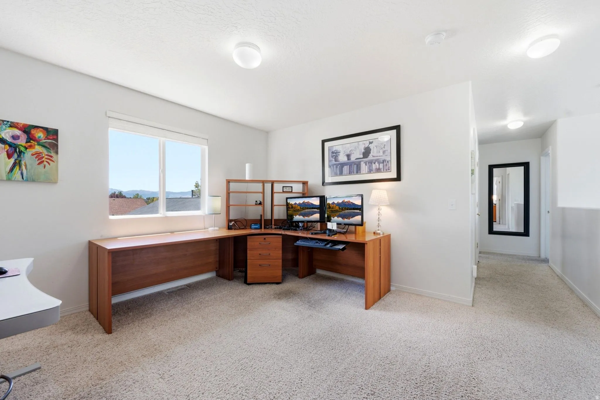 Light-filled room featuring a large window, neutral carpeting, recessed lighting, and a white wall finish