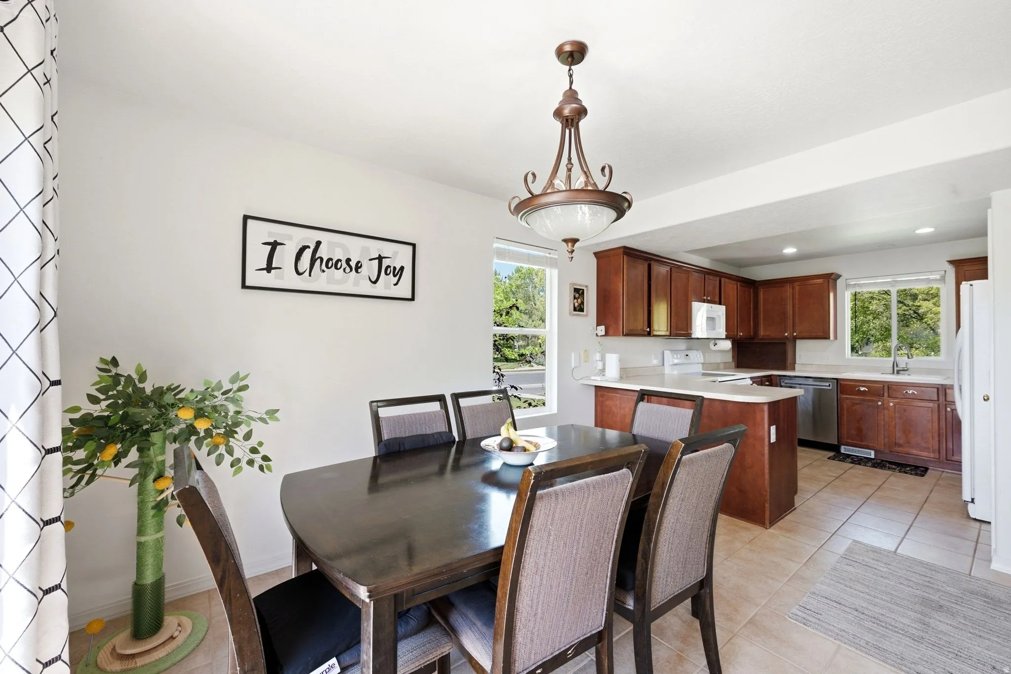 Dining area featuring a dark wood-finish table and chairs, illuminated by an ornate chandelier
