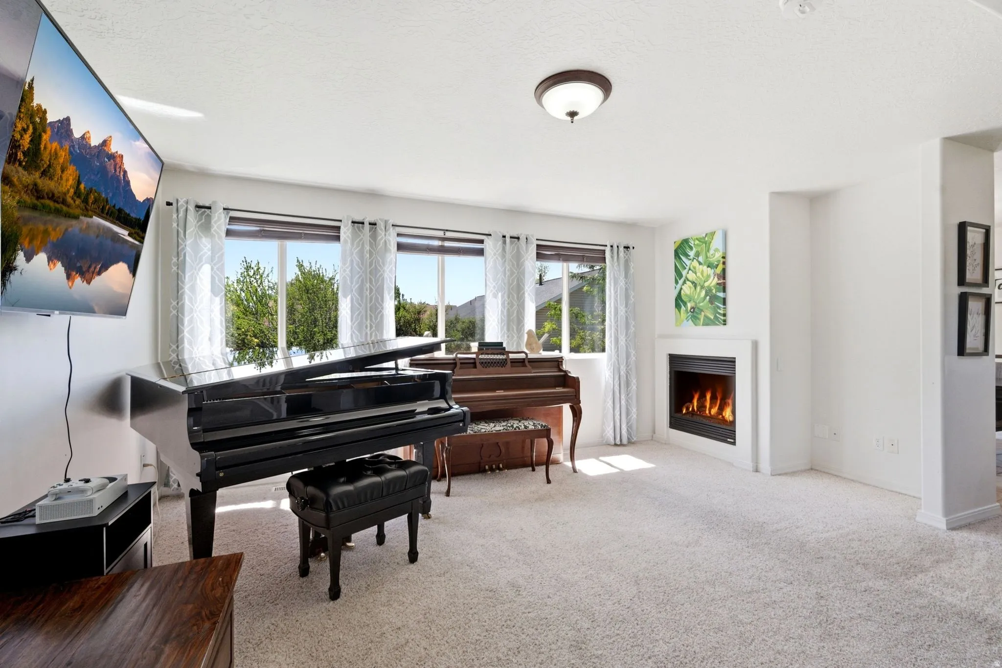 Bright living space featuring a built-in fireplace with a white surround, large windows, recessed lighting, and light-colored carpet flooring
