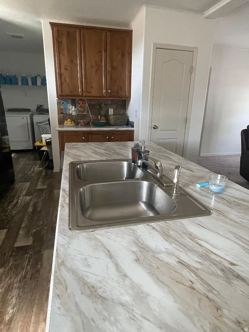 Kitchen island featuring a double basin stainless steel sink with a chrome faucet