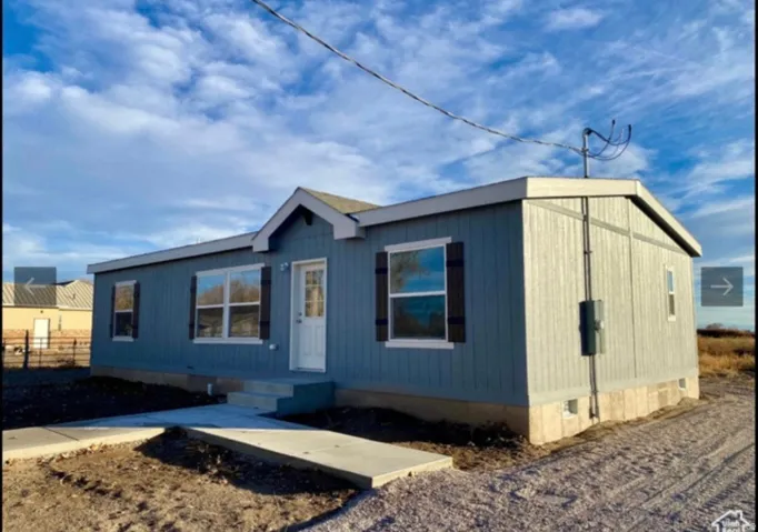 Single-story residential structure featuring light blue vertical siding and a white trim
