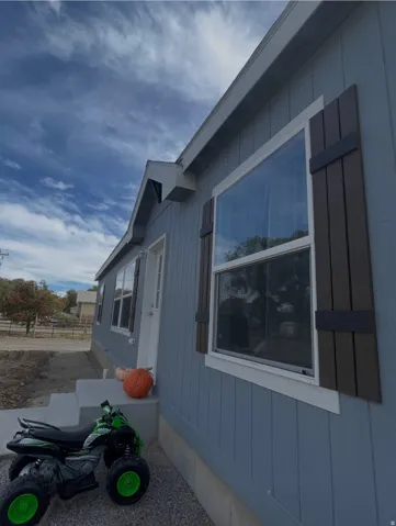 Light blue vertical siding exterior with contrasting dark brown window shutters