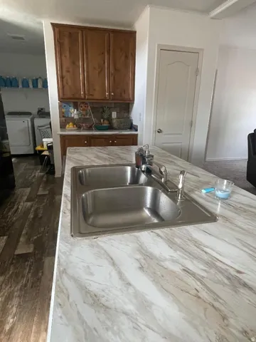 Kitchen island featuring a double basin stainless steel sink with a chrome faucet