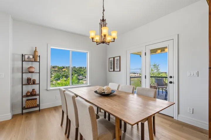 Dining area featuring wood-finish flooring, a contemporary chandelier, and white trim