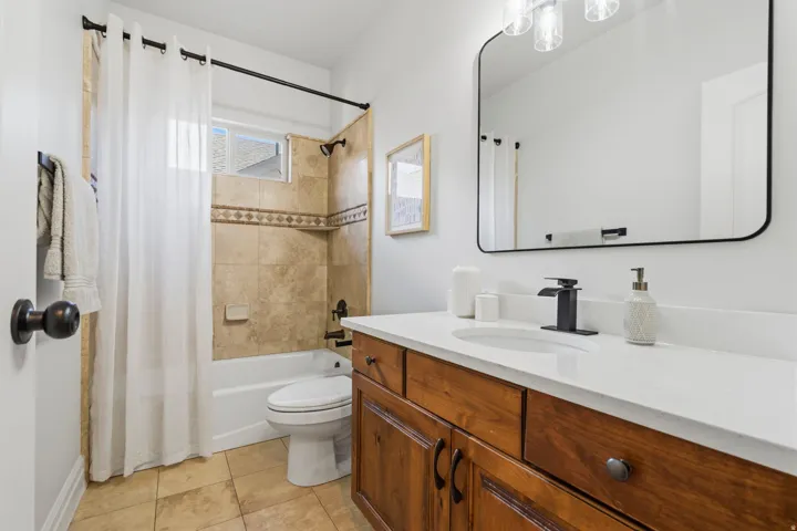 Bathroom featuring a wood-finish vanity with a white countertop and integrated sink