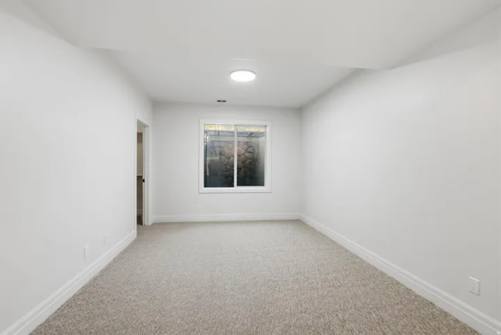 Room featuring light-colored carpeting, white walls, and white baseboards