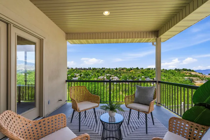 Covered balcony featuring a black metal railing, recessed lighting, and direct outdoor access through French doors