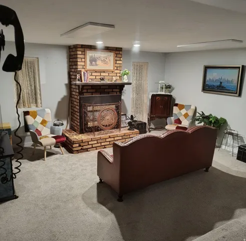 Brick-faced fireplace featuring a stone mantel and decorative fire screen