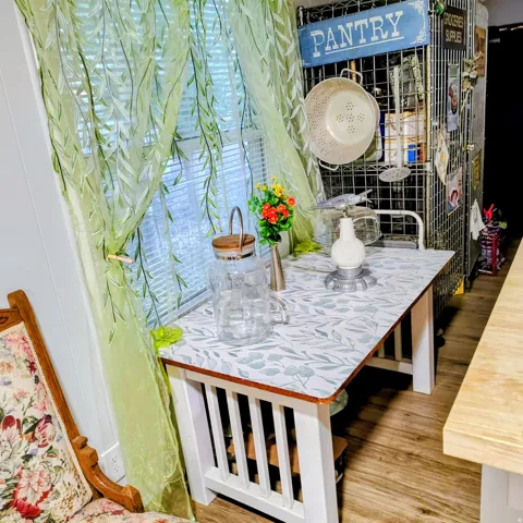 Dining nook with a patterned tabletop, white slat-panel base, and wood-finish flooring