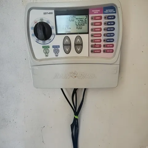 Rain Bird SST-400i irrigation control system with a digital display, push-button controls, and a zone selector dial