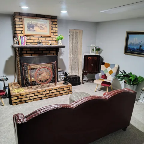 Brick fireplace with a dark wood mantel and a metal fire screen